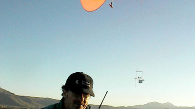 Man with a radio and an orange blimp in the background