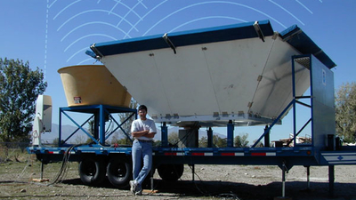 Large radar objects on back of trailer with man standing in front of it