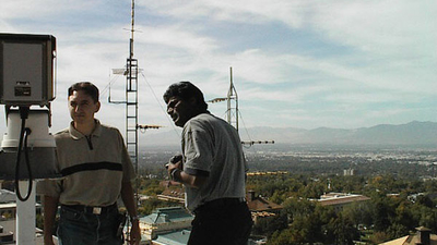 Two persons inspecting equipment on top of a high vantage point